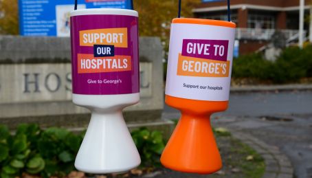 Our branded collection tins in front of the St George's Hospital sign.jpg